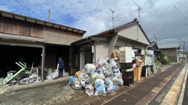 空き家の前にまとめられた、たくさんの袋と家財。