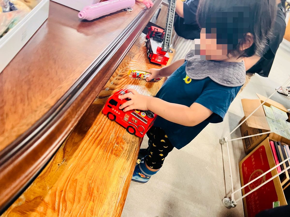 カウンターの上で、子どもがミニカーを走らせて遊んでいる。