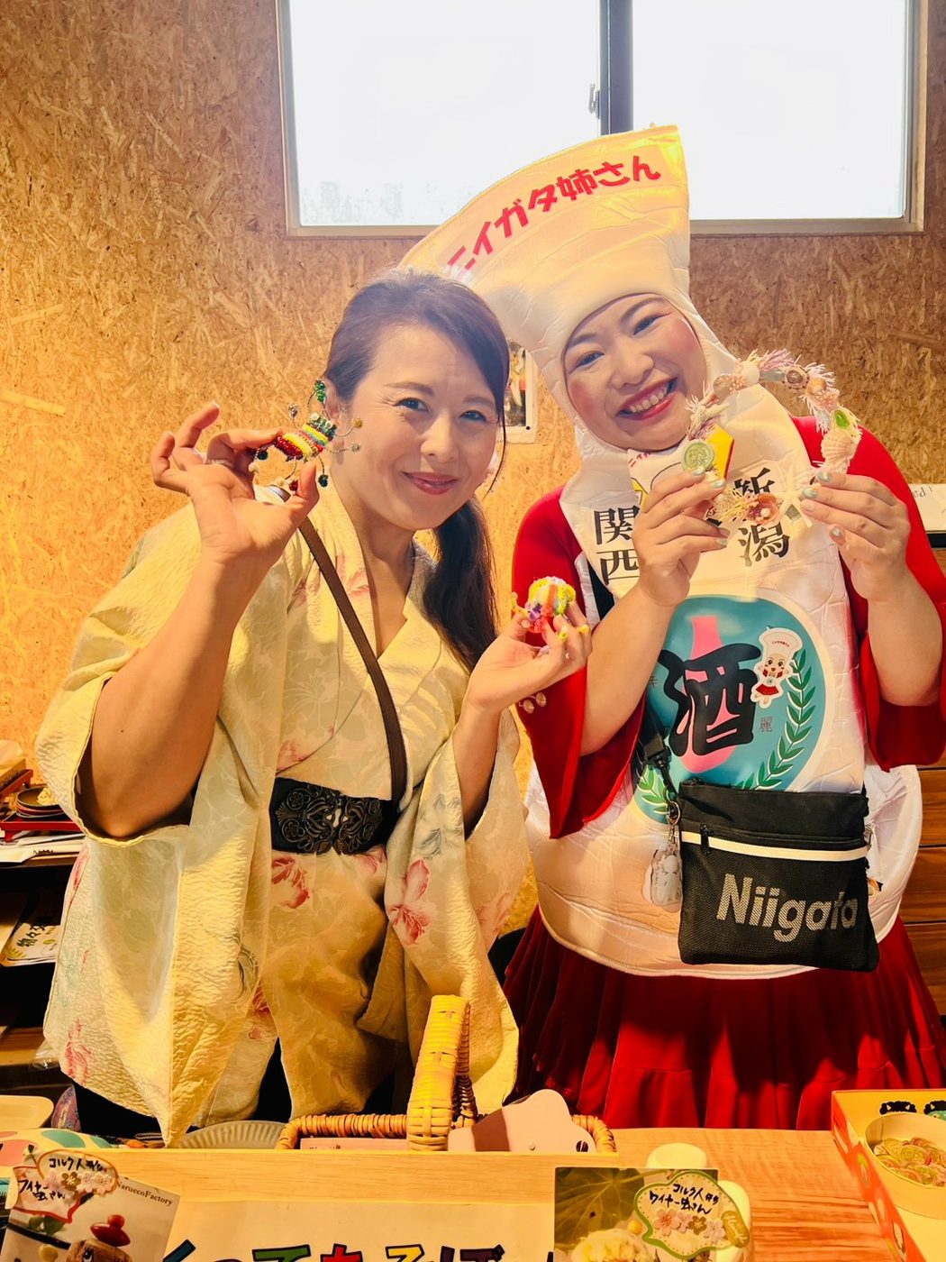 金色の着物を着た来場者とニイガタ姉さんが、笑顔でポーズをとっている。