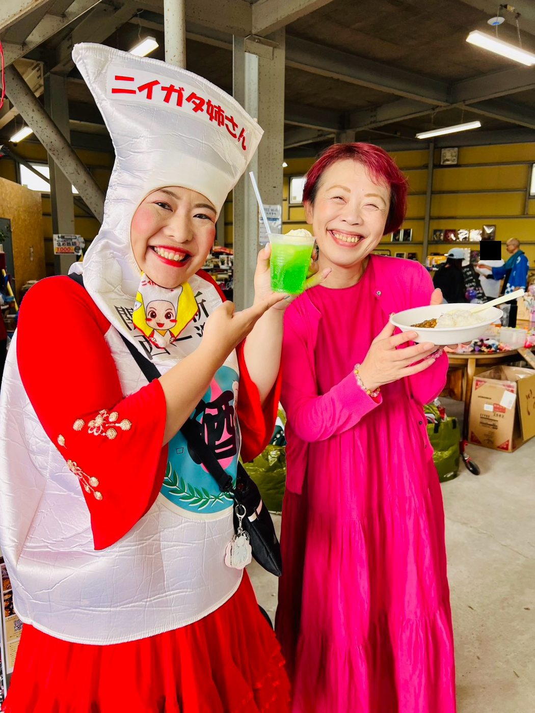 ニイガタ姉さんと来場者が、かき氷を手に笑顔でポーズをとっている。