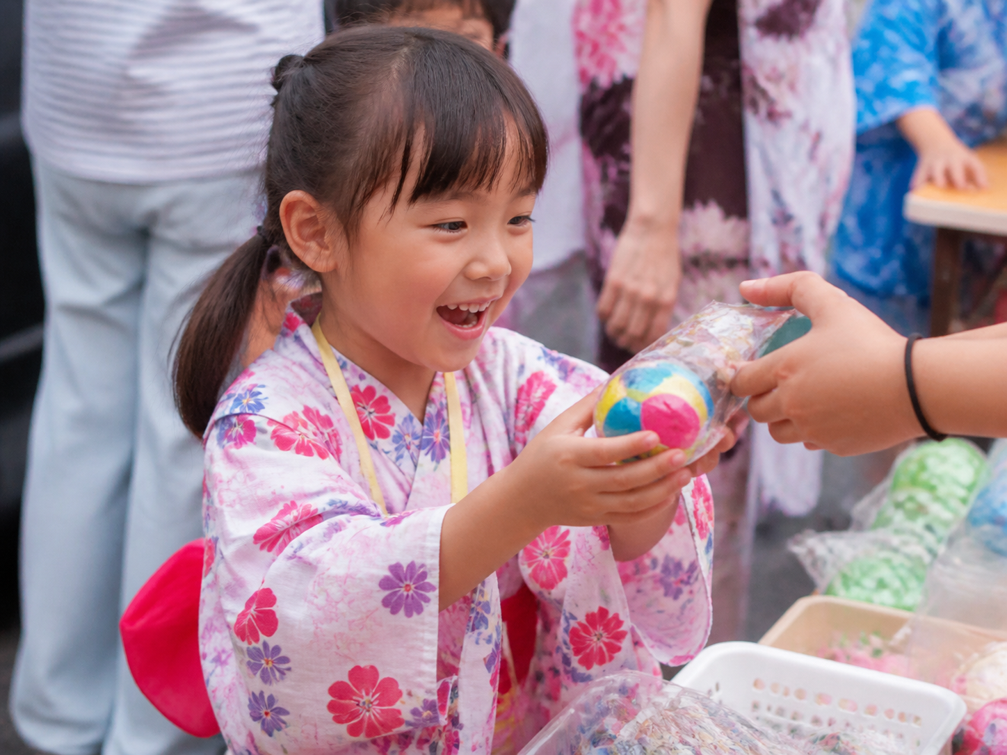 縁日で景品を受け取って笑う子ども