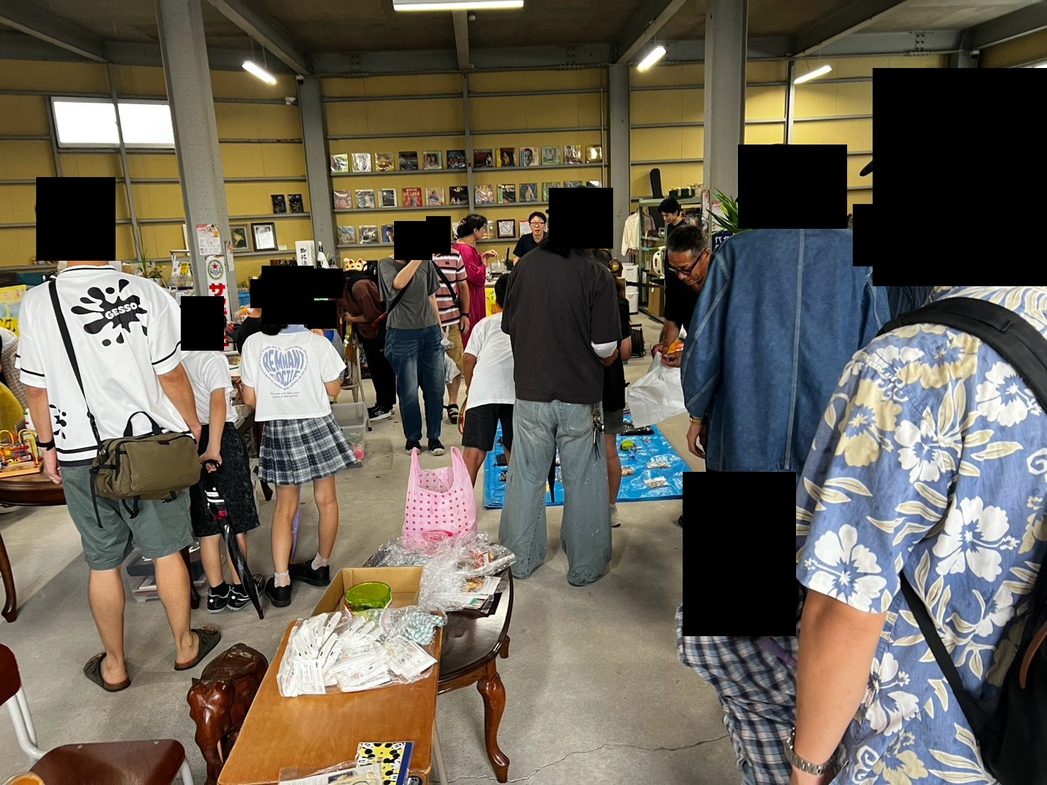 浴衣や甚平姿の来場者が、会場の棚や机に並んだ品物を見て回っている。