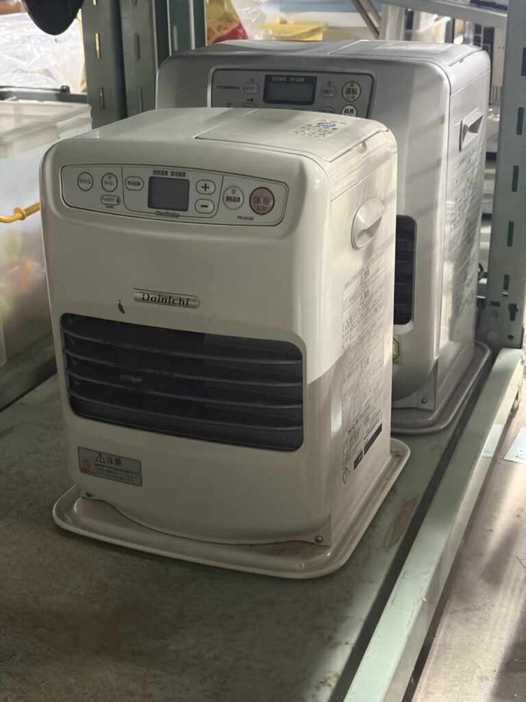 棚に並んだ、白とグレーの石油ファンヒーター2台。
