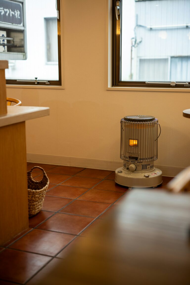 タイルの床の部屋に置かれた、丸い石油ストーブ。
