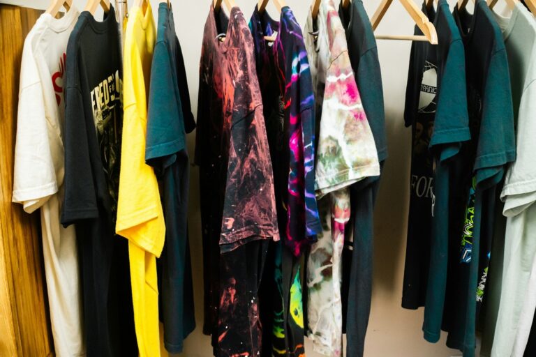 ハンガーにずらりと掛かった、色とりどりのTシャツ。