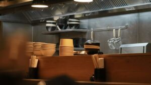 飲食店の厨房のカウンターに、同じ器が積み重ねられている。（イメージ）