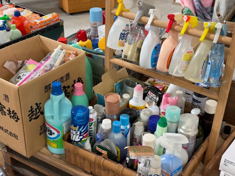 棚やかごに並んだ、洗剤やスプレーなどの日用品。